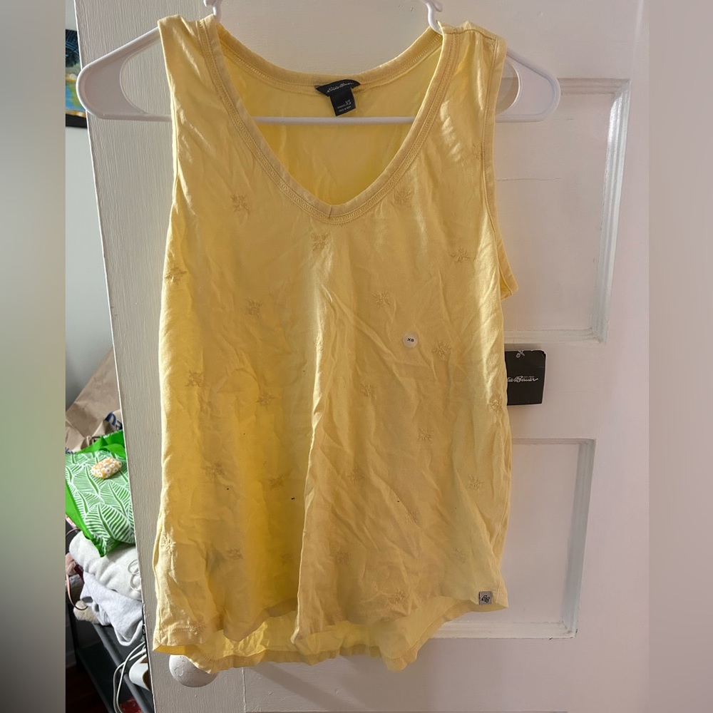 A yellow loose tank top with designs